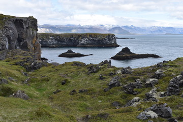 Hiking trail from Anarstapi to Hellnar with the raw ocean und big rocks and mountains in the west of Iceland at Snaefellsnes Peninsula