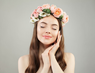 Cheerful woman with clear skin and flowers. Skincare and facial treatment