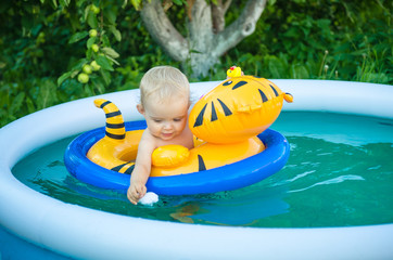 the child is swimming in an inflatable pool