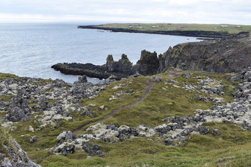 Hiking trail from Anarstapi to Hellnar with the raw ocean und big rocks and mountains in the west of Iceland at Snaefellsnes Peninsula