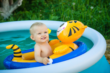 the child is swimming in an inflatable pool