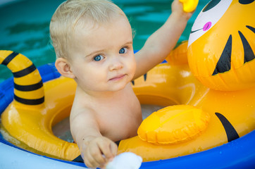 the child is swimming in an inflatable pool