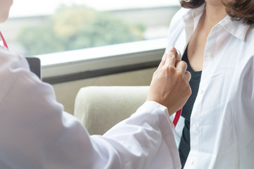 Professional medical doctor in white uniform gown coat interview counseling female patient: Physician writing on patient chart while consultation: Hospital/ clinic healthcare professionalism concept