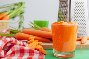 Glasses of carrot juice with vegetables on table close up