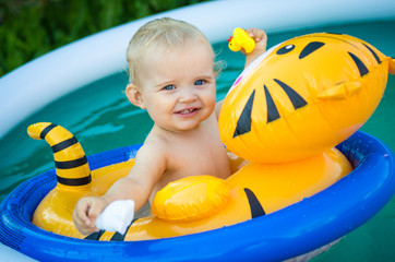the child is swimming in an inflatable pool