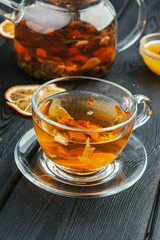 Cup of tea and tea leaves on wooden table