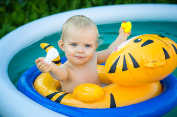 the child is swimming in an inflatable pool