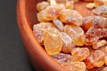 brown sugar rock organic crystalline close up on dark background