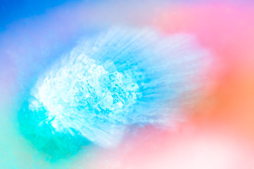 Fototapeta premium Abstract background of blurred bright colorful neons and diverse watercolor paint splash. Closeup of African Blue Eye Cabo Verde aquatic landmark on hazy rainbow wallpaper.