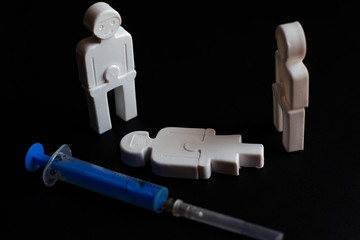 illustration of the effects of addiction. little plastic men with a syringe. concept 
