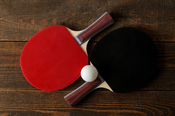 Two ping pong rackets. Table tennis rackets and a ball on a brown wooden table. sport game. top view