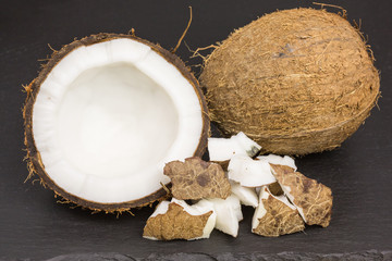 fresh coconut pieces with coconut half and whole coconut