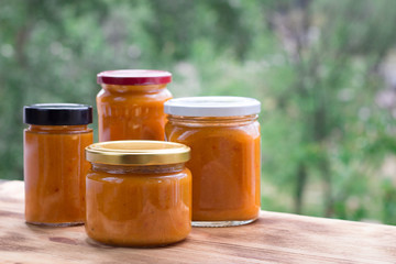 Summer composition of apricot jam cans prepared from berry harvest