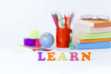 word learn on the background of school supplies