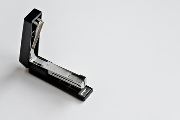 Stapler black with paper clips isolated on white background.