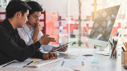 Young startup ux ui front end designers developing programming and coding responsive web content or mobile app from prototype and wireframe layout.