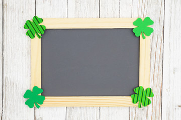 Blank chalkboard with green shamrocks on weathered whitewash textured wood background