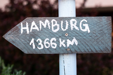 grey sign with white font which points to Hamburg