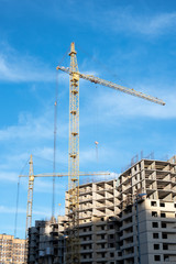 Crane in the process of building a new building against the sky