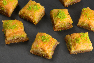 Pistachio baklava on a black plate. Dessert.