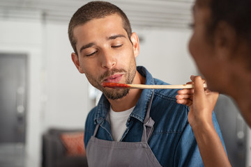 Man tasting tomato sauce