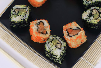 different types of Maki sushi on a black plate