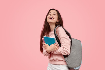 Fototapeta Excited student laughing and hugging notebooks obraz