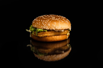 Burger with sesame and chicken meat on black background