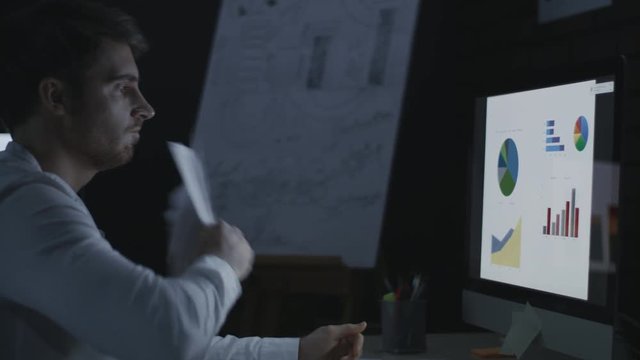 Evil business man throwing data document on computer table in dark office
