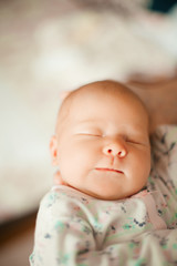 funny newborn baby sleeps in the arms of his mother