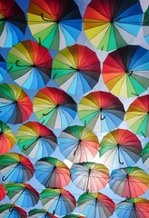 Fototapeta na wymiar A huge number of umbrellas rainbow-colored fly into the sky