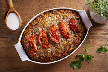 Beef rice and cabbage casserole in white baking dish on wooden table
