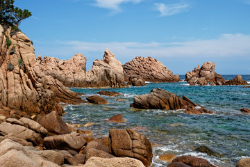 Red rock formation at a beach at La Sorgente, Costa Paradiso in Sardinia (Italy) with turquoise blue sea