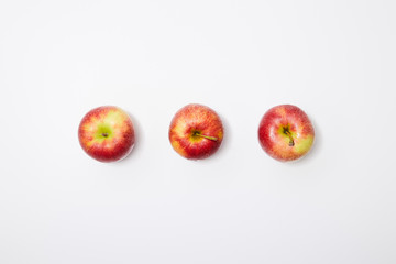 top view of red apples in row on white background