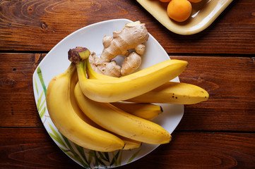 fresh fruits  banana and apricots laying at  wooden table. flat lay