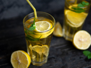 Summer lemonade Mojito with lemon and mint in glasses on a dark table
