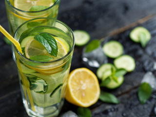 Summer cold lemonade with cucumber lemon mint Basil and ice in glasses