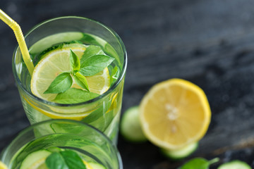 Summer cold lemonade with cucumber lemon mint Basil and ice in glasses