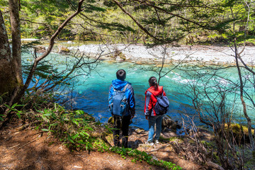 Azusa turquoise color river at Kamikochi in Northern Japan Alps with man and woman.