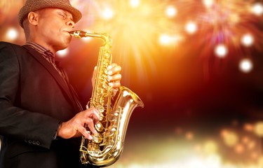 Close-up man playing on saxophone on blurred background