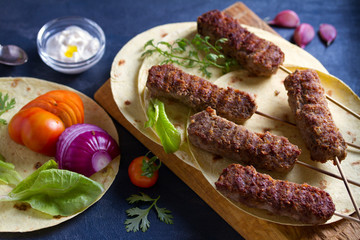 Kofta kebabs with pita bread, vegetables and yogurt sauce