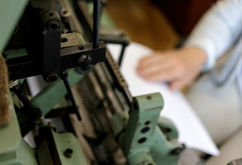 Machine for stitching book pages with threads in typography.