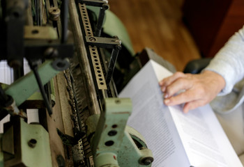 Machine for stitching book pages with threads in typography.