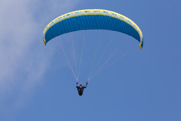 Colorful paraglider wing or canopy against blue sky with clouds