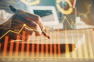 Financial forex charts displayed on woman's hand taking notes background. Concept of research. Double exposure