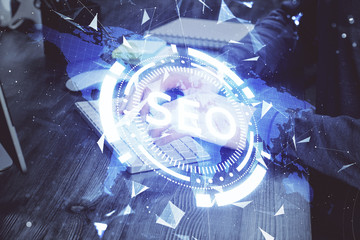Multi exposure of seo icon with man working on computer on background. Concept of search engine...