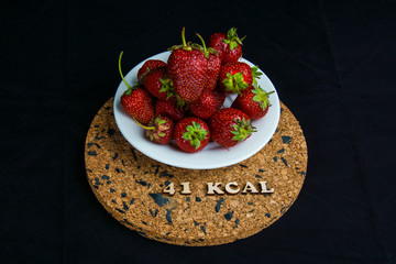 a series of calorie foods strawberries 41 kcal per 100 grams on a black background