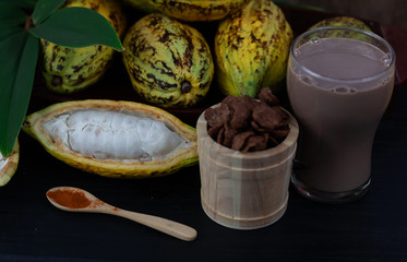 Fresh cacao fruit with cocoa crunch (Products Production from cacao) on table