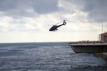 Hubschrauber startet von einer Platform am Meer