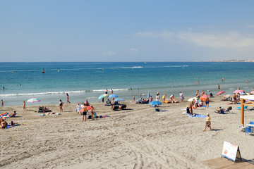 Holidaymakers enjoy summer vacation beach holidays on seaside near Mediterranean Sea of Cabo Roig sandy coast, sunbath and swim, Torrevieja, Costa Blanca, Spain